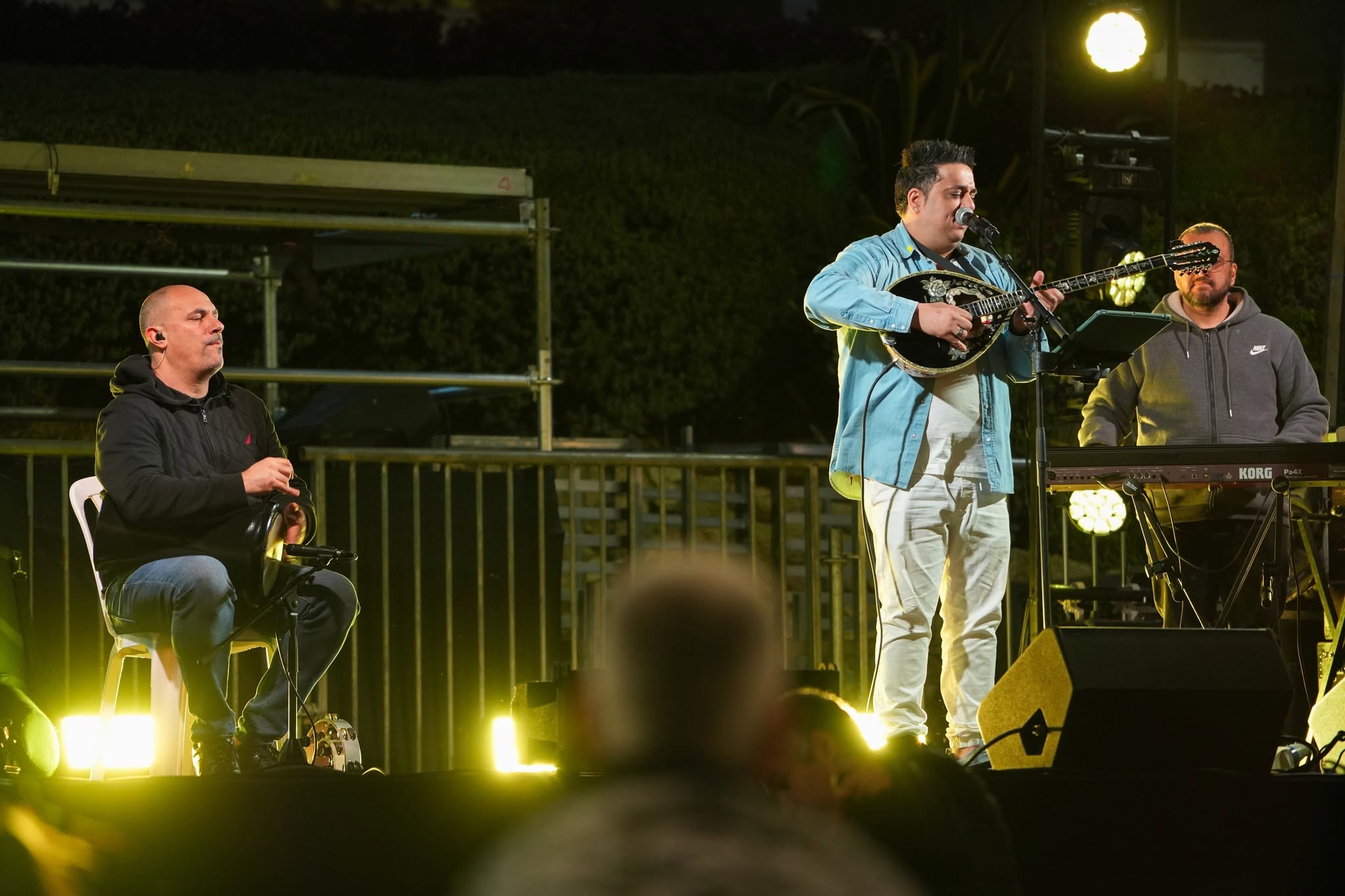 Musicians perform on a small stage before an audience.