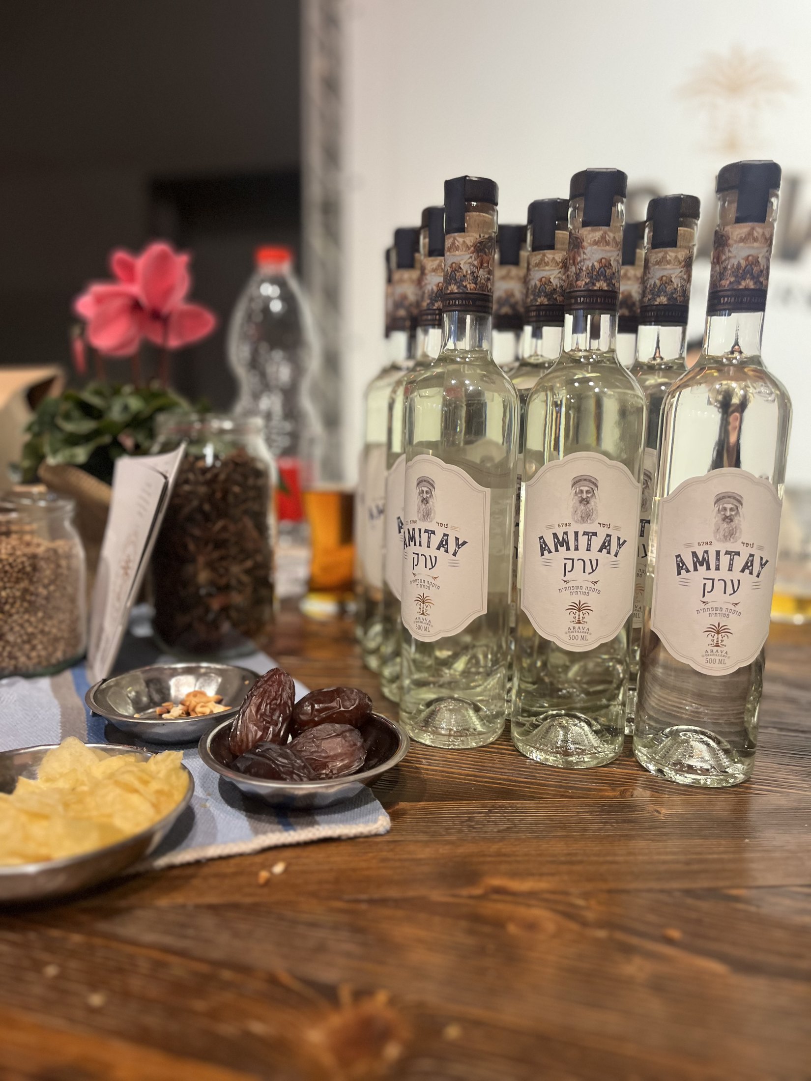 Clear spirits bottles and flowers on a display table.