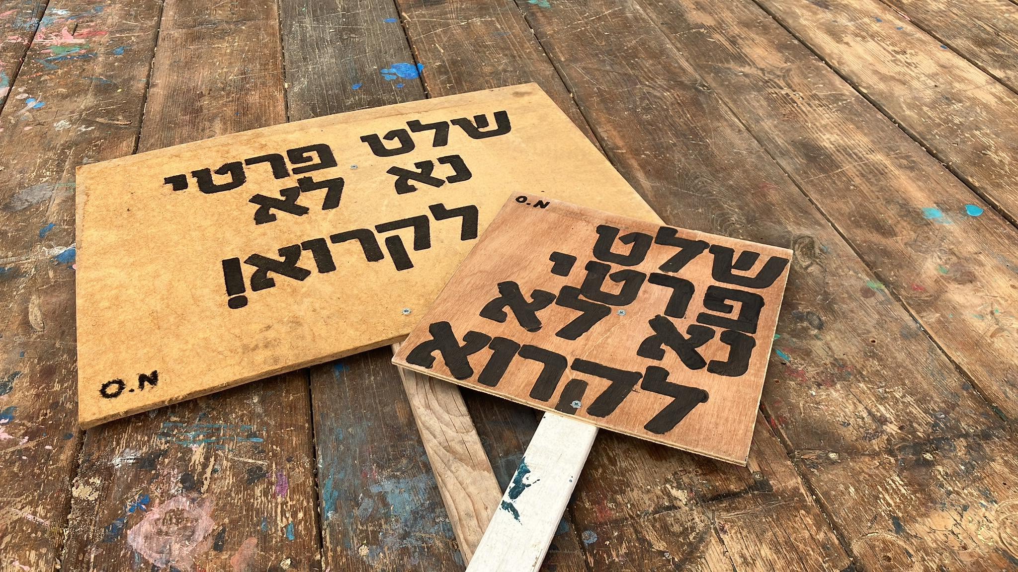 Hand-lettered wooden signs lie on a table.