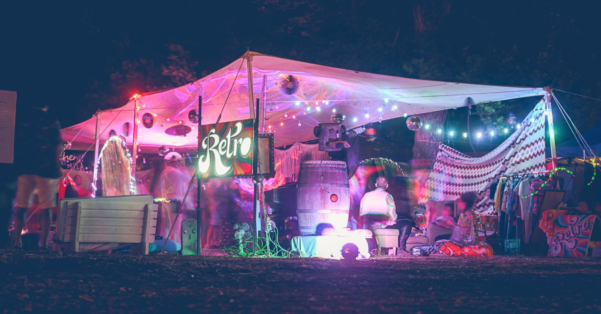 A Retro tent lit pink and purple at night.